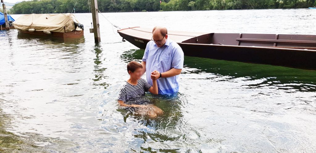 Pastor Ramun Badertscher der FEG Wilchingen tauft am Rhein in Schaffhausen 